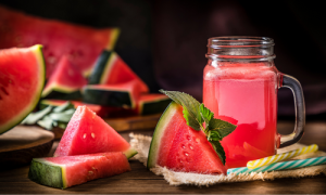 Gesneden watermeloen op een houtentafel met een glas watermeloen sap